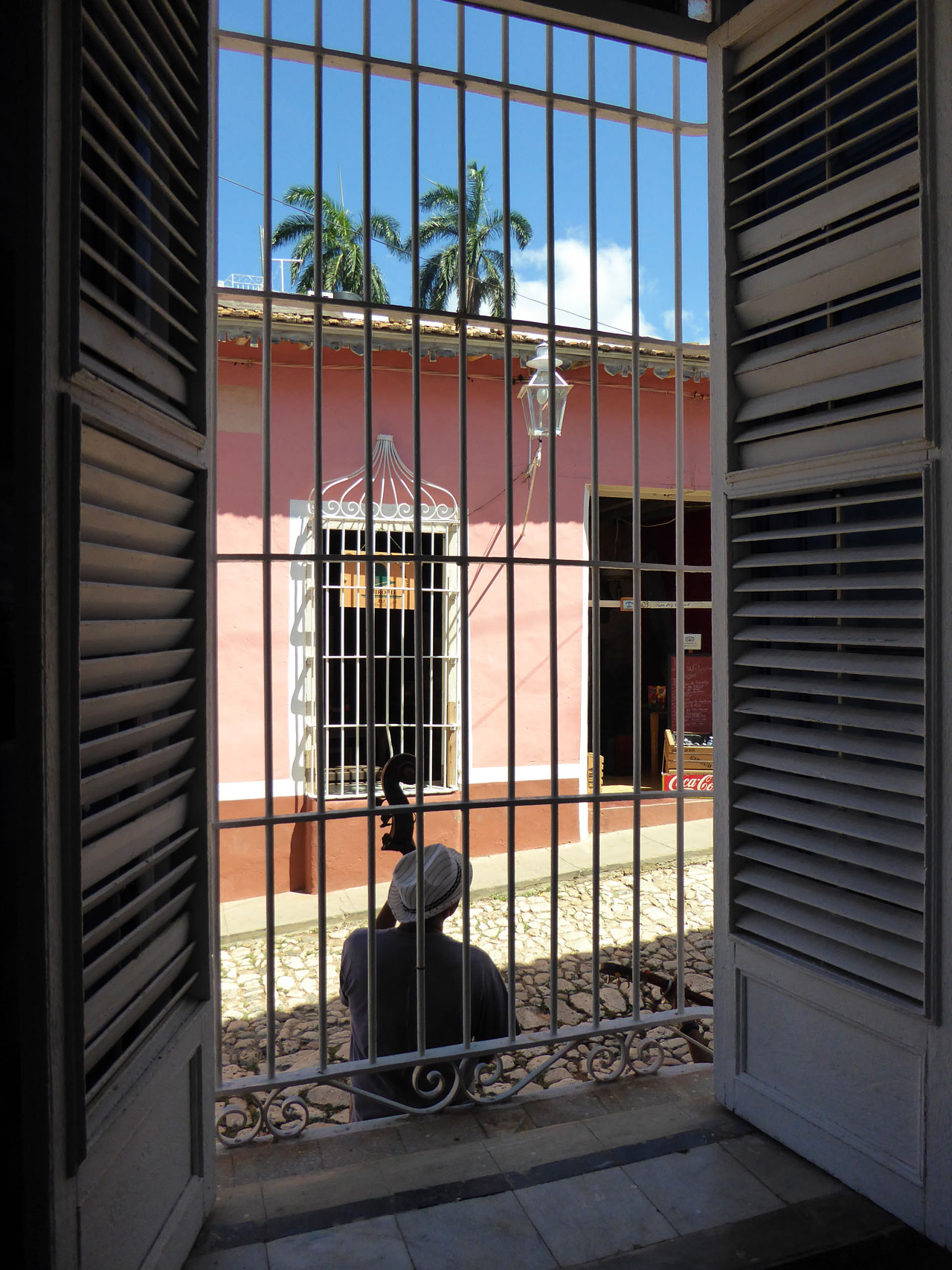 Musician viewed through a cage window in Trinidad, Cuba